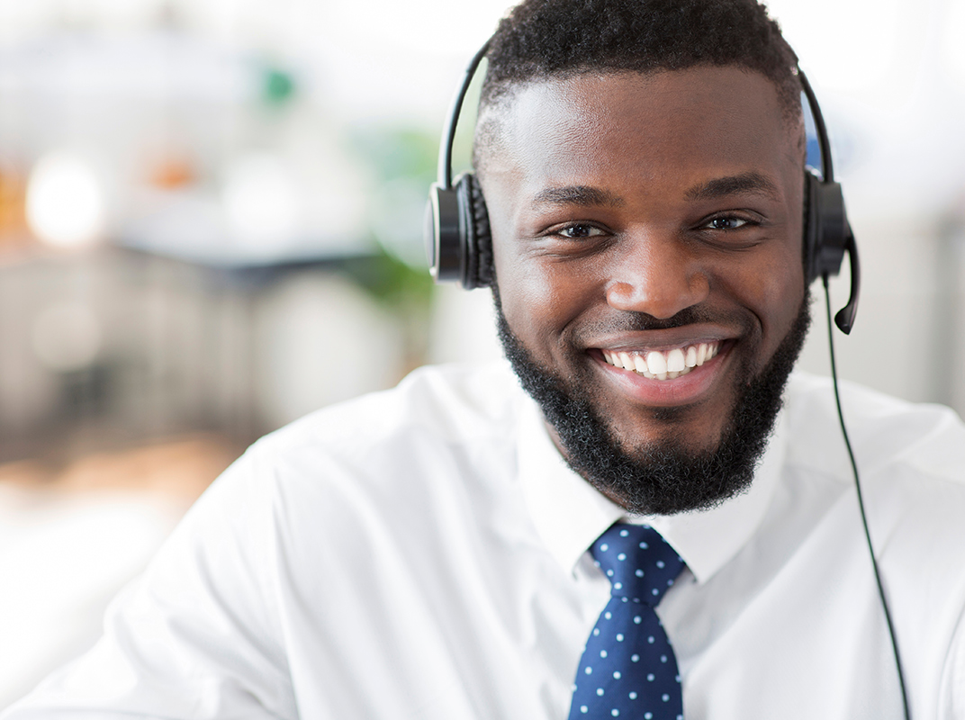 Smiling customer service representative wearing a headset.							
