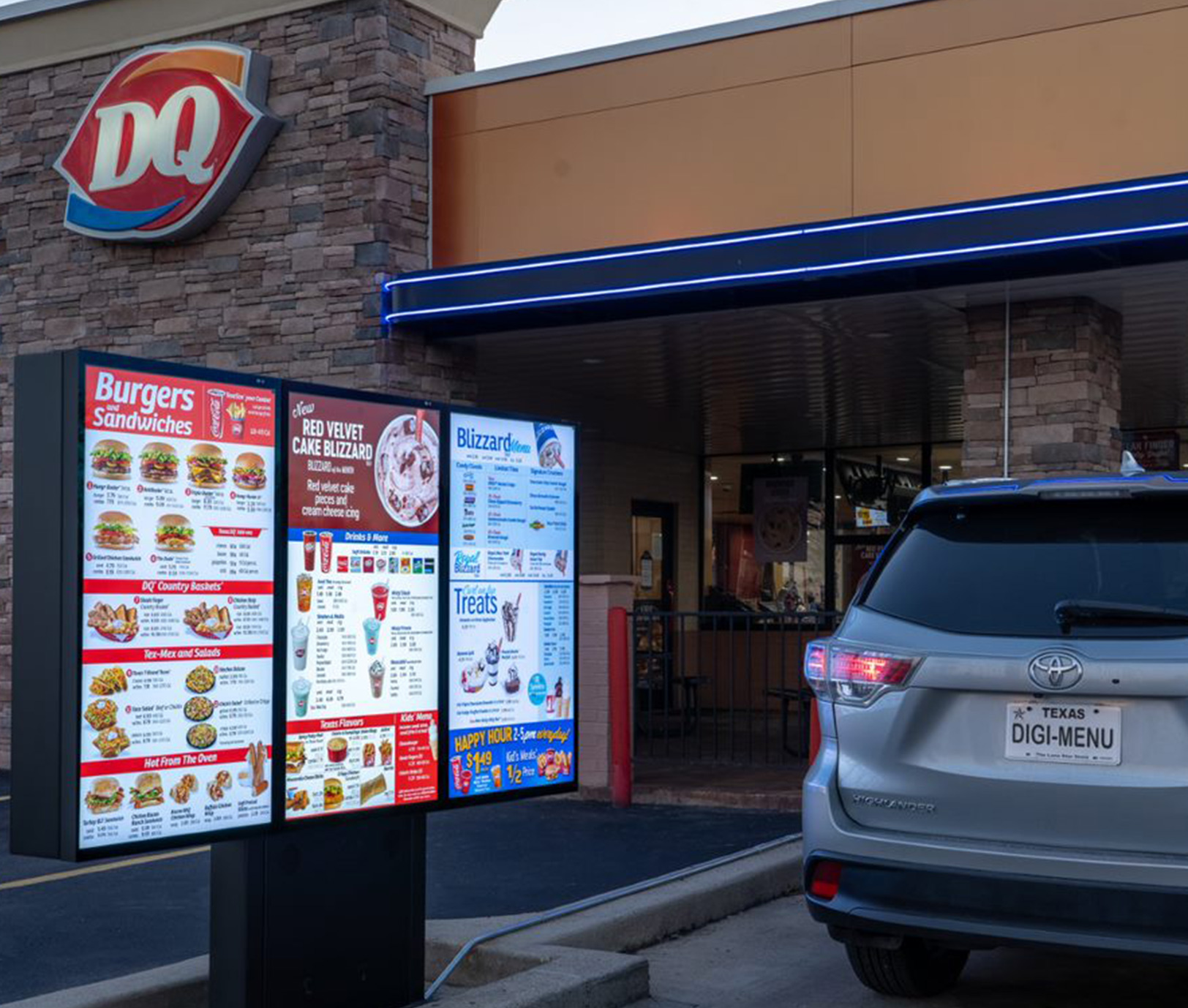 An angled view of a bright, three-panel Dairy Queen drive-thru menu.							
