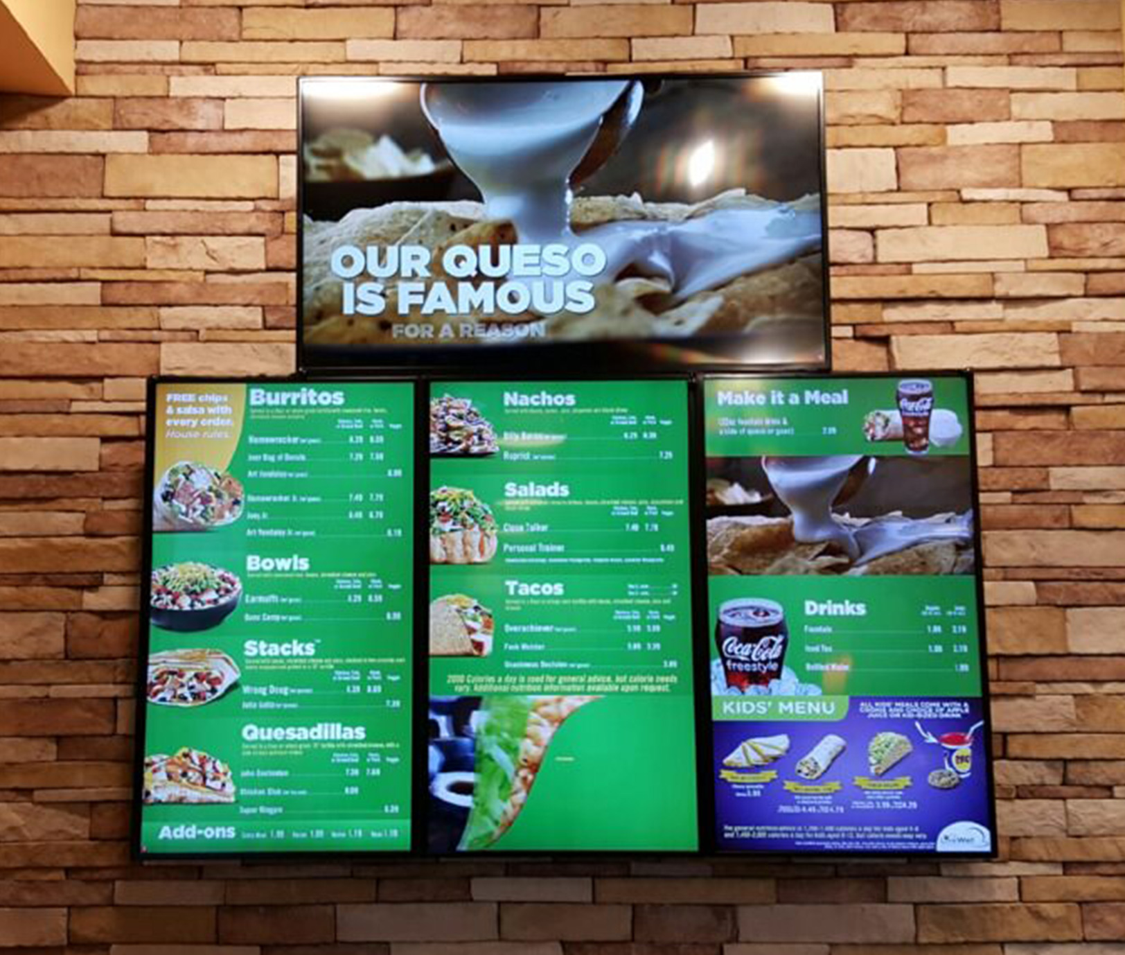 One large digital menu is mounted above three vibrant vertical menu boards showing images of tacos, nachos, and drinks.
