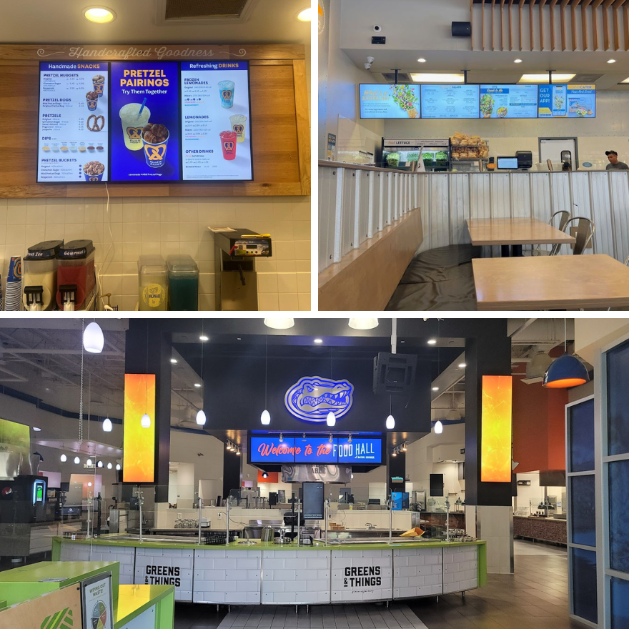 A Cinnabon storefront showing a white countertop, two employees, and vertical digital display showcasing a wild berry cinnamon bun.